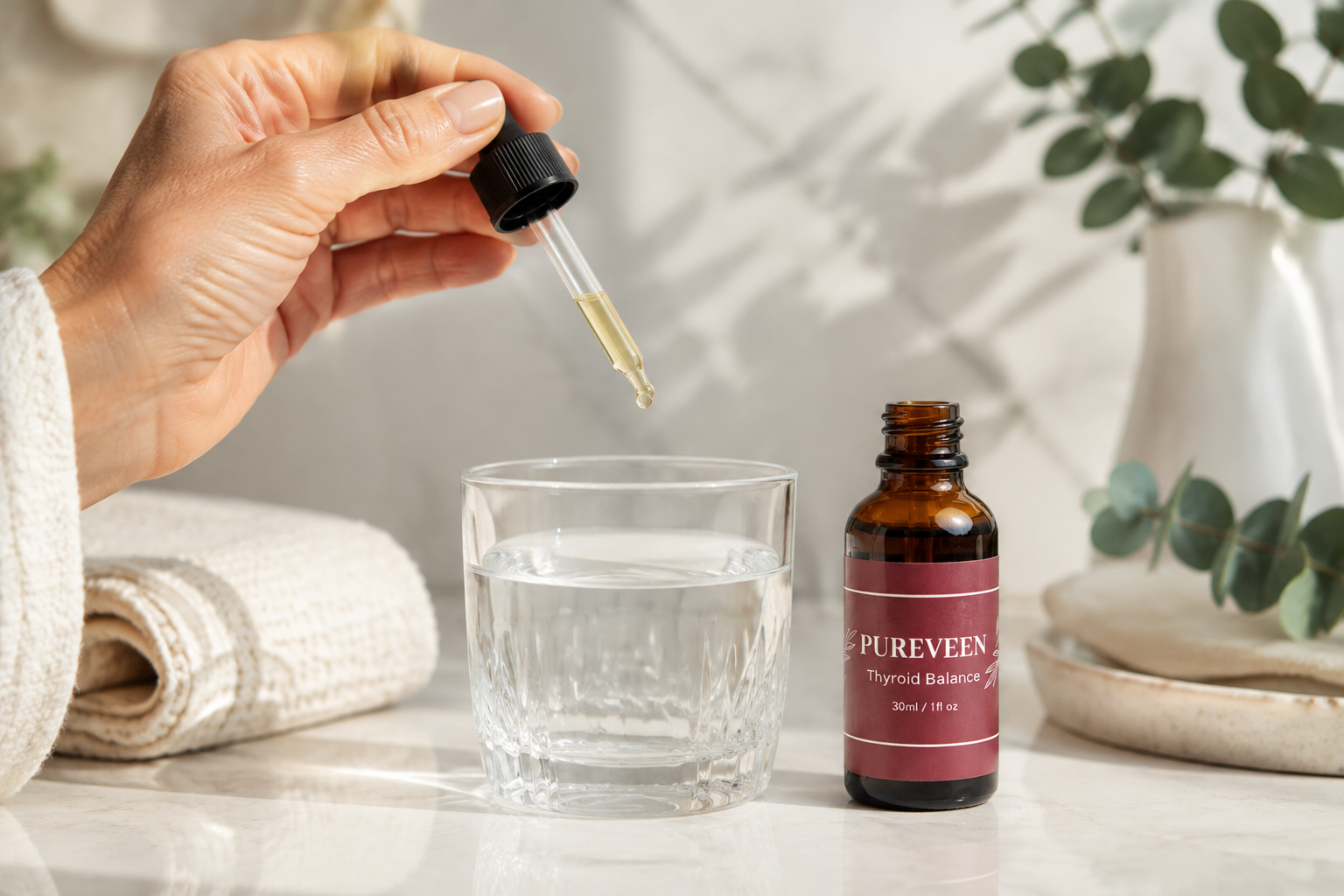 Pureveen Thyroid Balance liquid dropper beside a glass of water